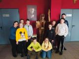 Grupa uczniów szkoły podstawowej w teatrze. za nimi drewniana rzeźba Pinokia