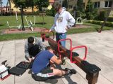 Troje uczniów remontujących huśtawkę równoważną