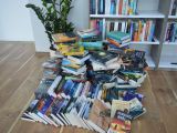 Stos książek ułożony na podłodze.